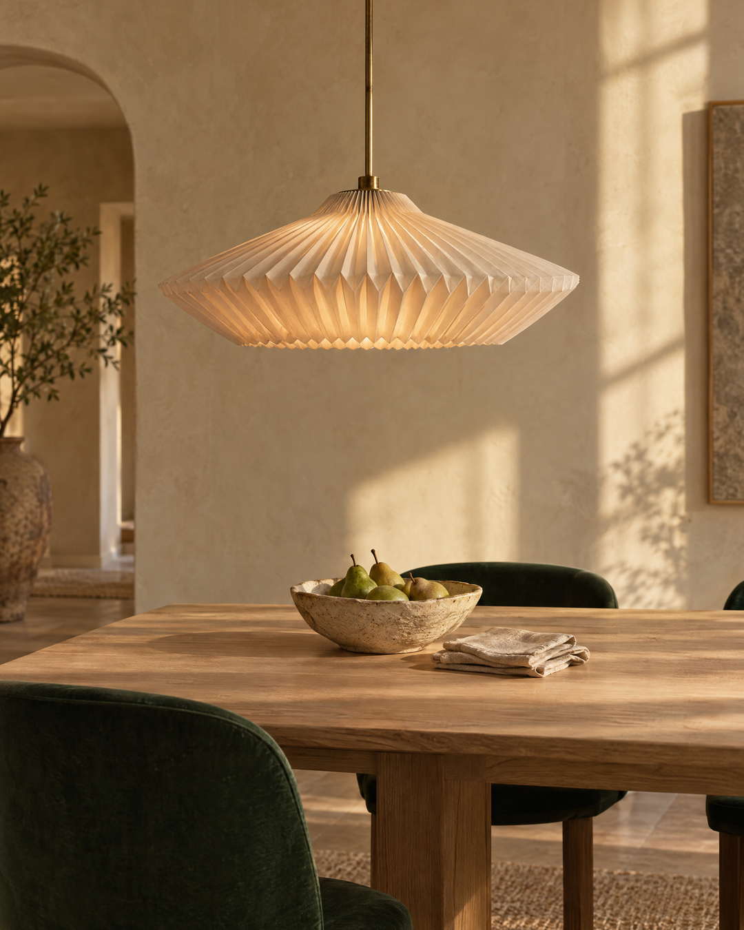 Sculptural paper pendant light glowing over an oak dining table