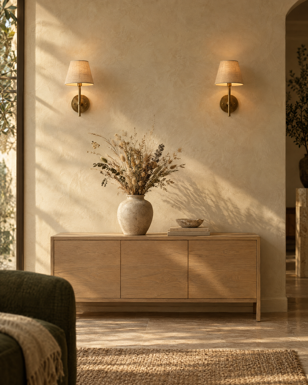 Pair of brass wall lights with linen shades above an oak console