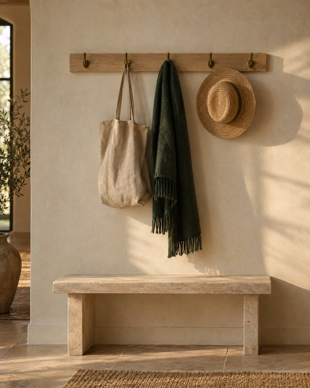 Oak peg rail with brass hooks in a calm entryway